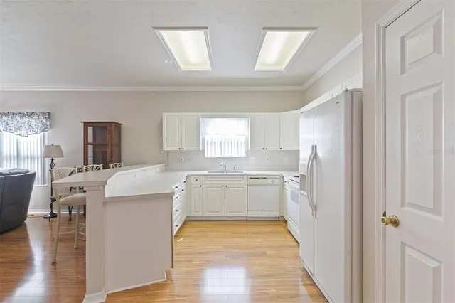 a kitchen with a refrigerator a sink dishwasher with a dining table and chairs