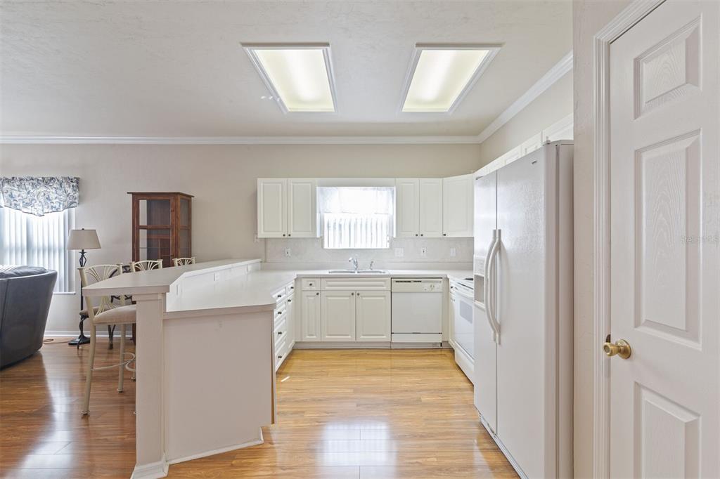 4748 Northwest 77 Road Gainesville, FL 32653 - Photo 6 of 21 a kitchen with a refrigerator a sink dishwasher with a dining table and chairs