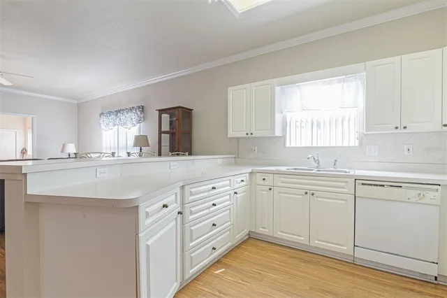 a kitchen with granite countertop white cabinets white appliances and sink