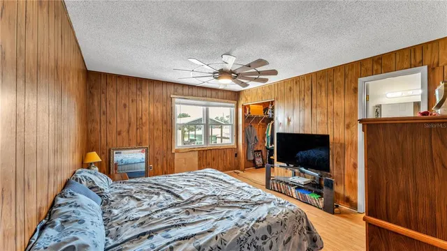 a bedroom with a bed and a flat screen tv