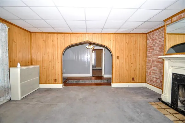 an empty room with chandelier fan and windows