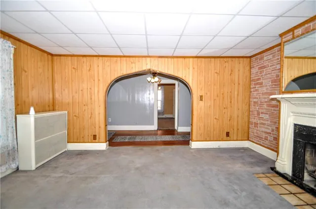 an empty room with chandelier fan and windows