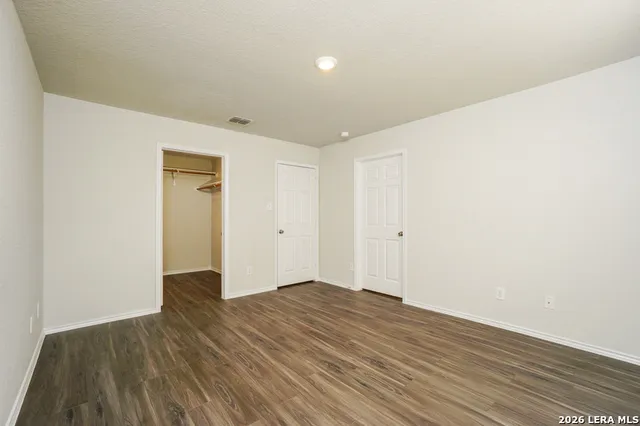 a view of an empty room with wooden floor