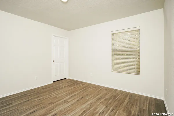 an empty room with wooden floor and a window