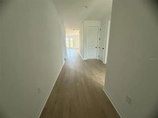 a view of a hallway with wooden floor
