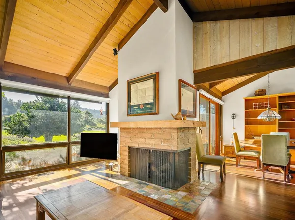 a living room with furniture a fireplace and a floor to ceiling window
