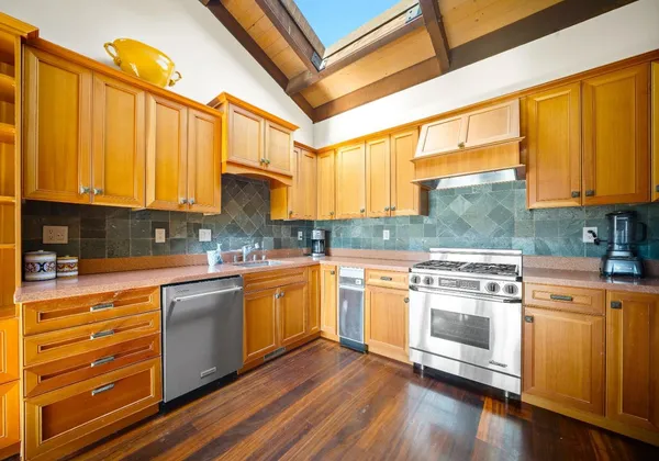 a kitchen with stainless steel appliances granite countertop wooden cabinets a sink and a stove
