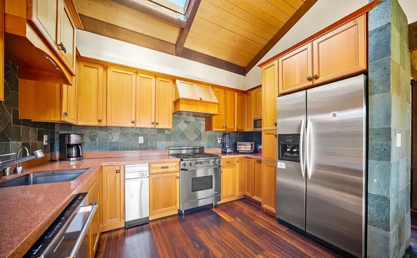 a kitchen with stainless steel appliances a refrigerator a stove a sink and cabinets