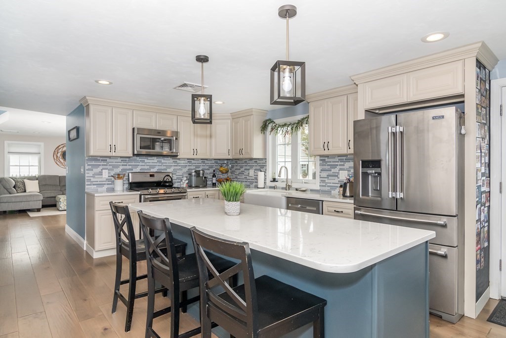 15 Sheffield Road Natick, MA 01760 - Photo 3 of 30 a kitchen with stainless steel appliances a sink a stove a refrigerator and chairs