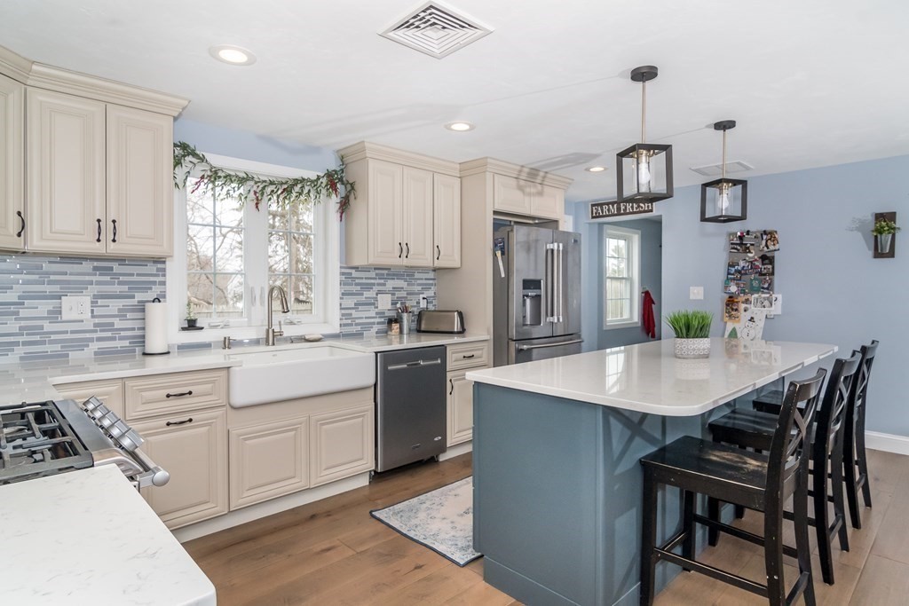 15 Sheffield Road Natick, MA 01760 - Photo 5 of 30 a kitchen with stainless steel appliances kitchen island a table chairs sink and cabinets