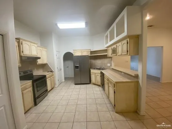 a kitchen with stainless steel appliances granite countertop a stove a sink and a refrigerator