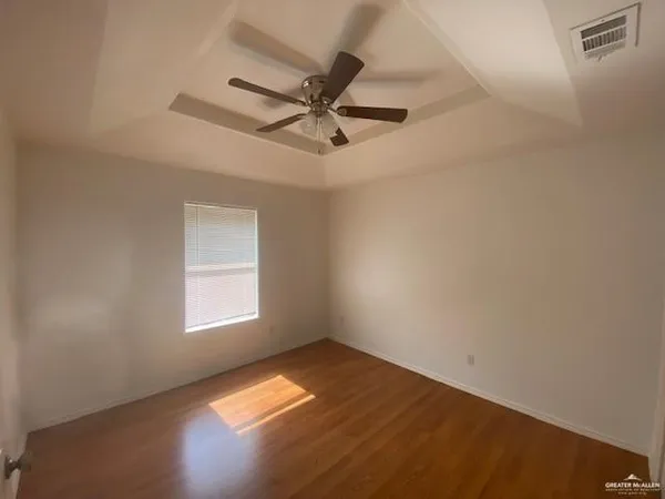 an empty room with a window and ceiling fan
