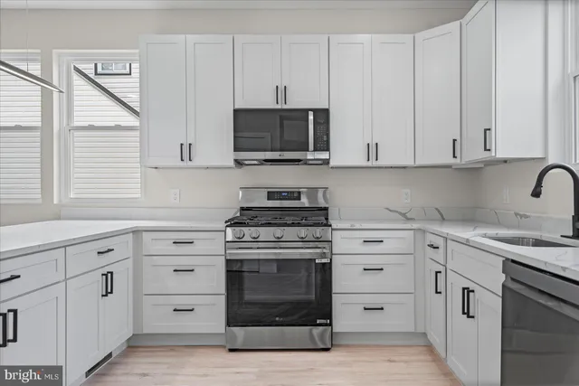 a kitchen with white cabinets and appliances