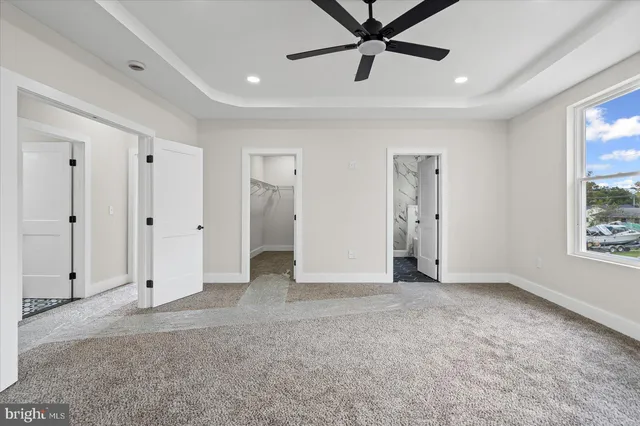 an empty room with fan and windows