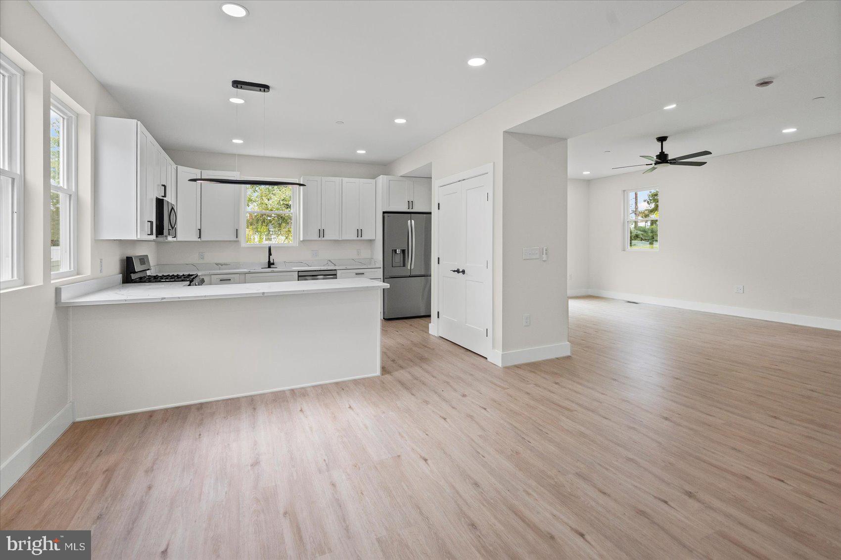 9534 Bauer Avenue Baltimore, MD 21236 - Photo 4 of 53 a large kitchen with stainless steel appliances a large window a wooden floor and a sink