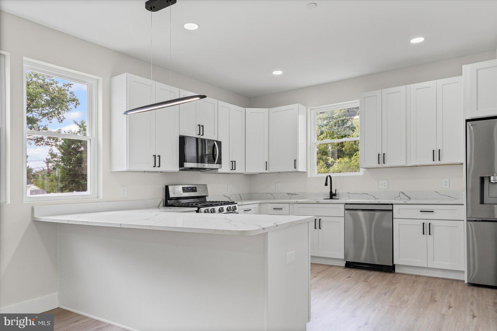 9534 Bauer Avenue Baltimore, MD 21236 - Photo 10 of 53 a kitchen with stainless steel appliances a sink a stove a microwave a refrigerator and cabinets