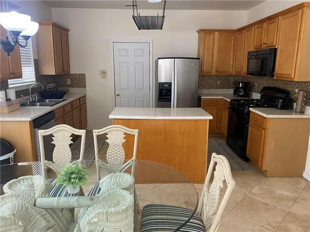 a kitchen with stainless steel appliances a refrigerator a stove a microwave a sink and cabinets