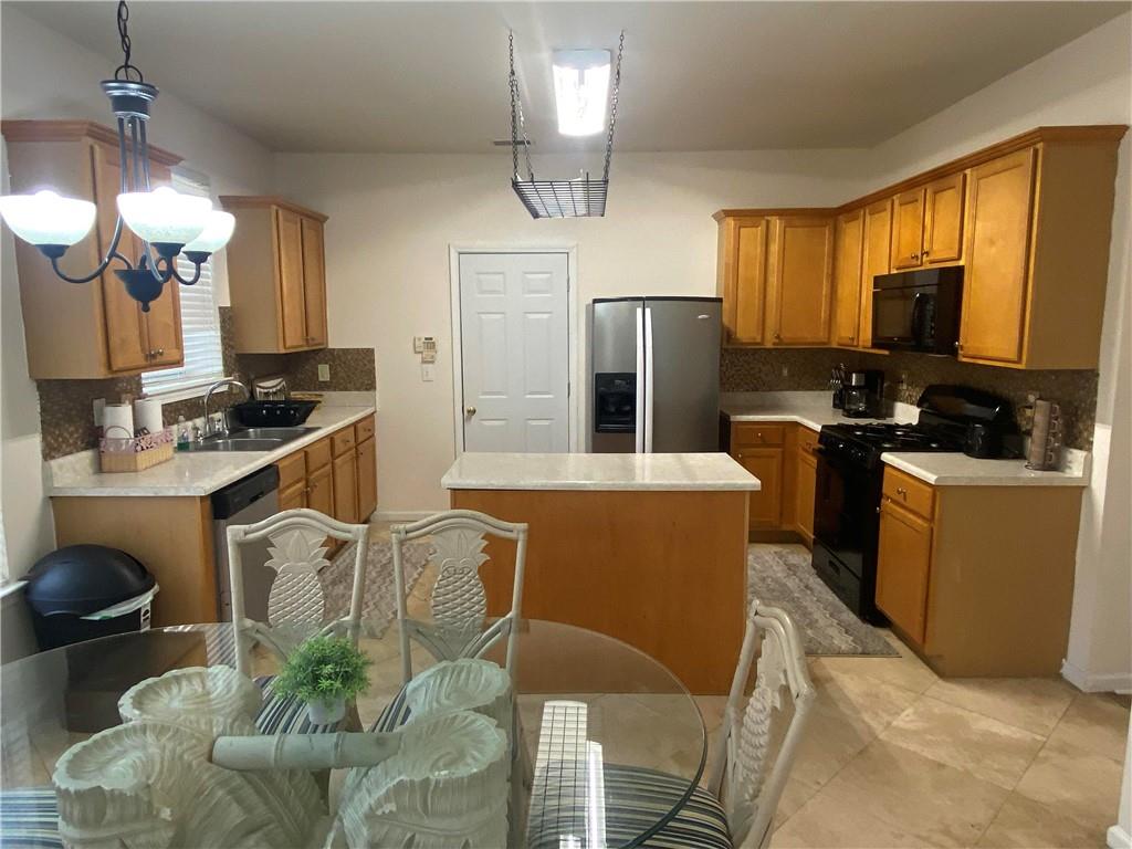 541 Cascade Hills Court Southwest Atlanta, GA 30331 - Photo 16 of 38 a kitchen with stainless steel appliances granite countertop a stove a refrigerator a sink a dining table and chairs with wooden floor