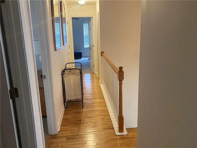 a view of a hallway with wooden floor and staircase