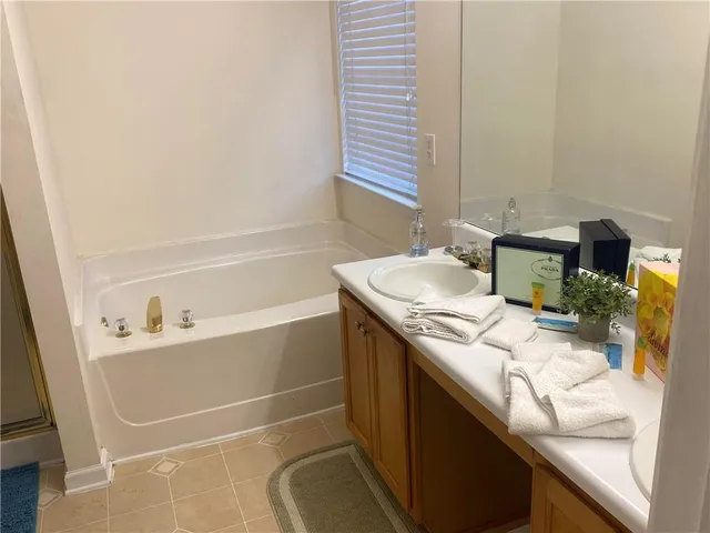 a bathroom with a sink vanity and tub
