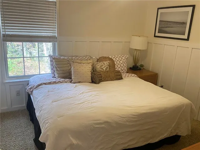 a large bed sitting in a bedroom next to a window