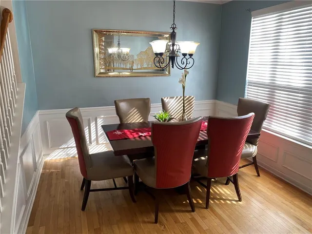 a view of a dining room with furniture wooden floor and a chandelier