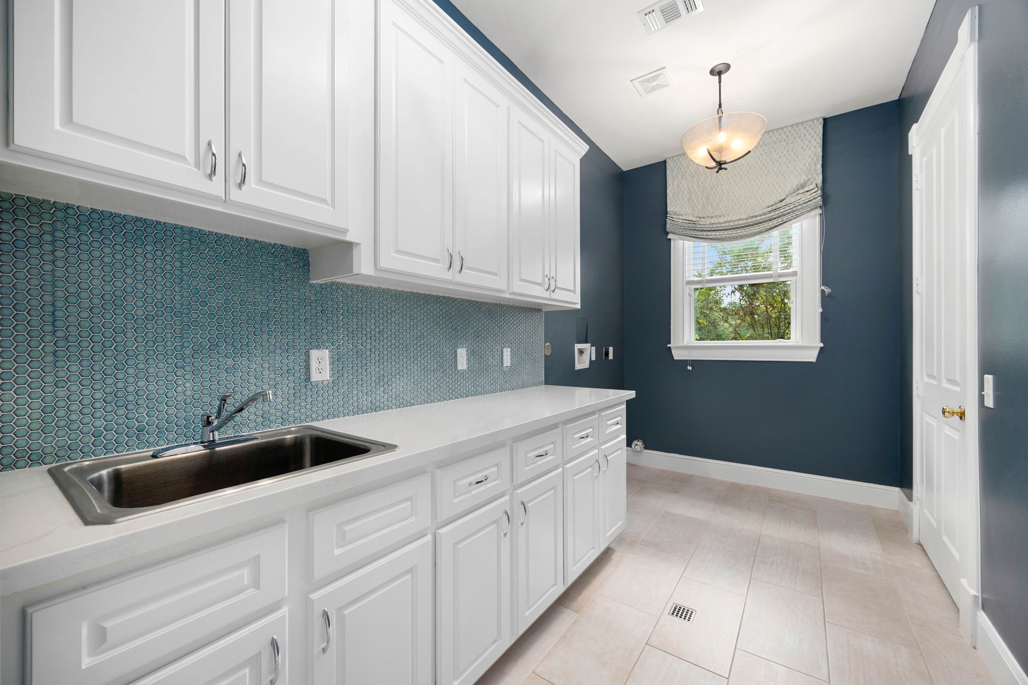 6039 Franz Road Katy, TX 77493 - Photo 33 of 49 The oversized laundry room features water softener system, quartz countertop and hexagon tile backsplash, extensive cabinetry, and a utility sink, thoughtfully upgraded for both function and style.