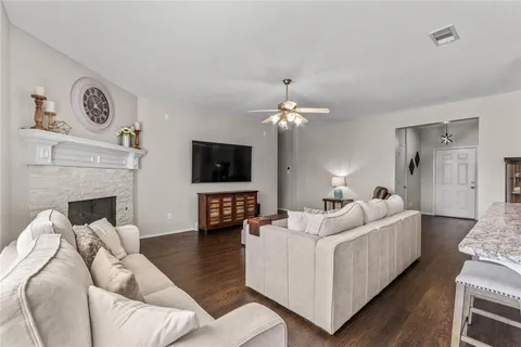 a living room with furniture a flat screen tv and a fireplace