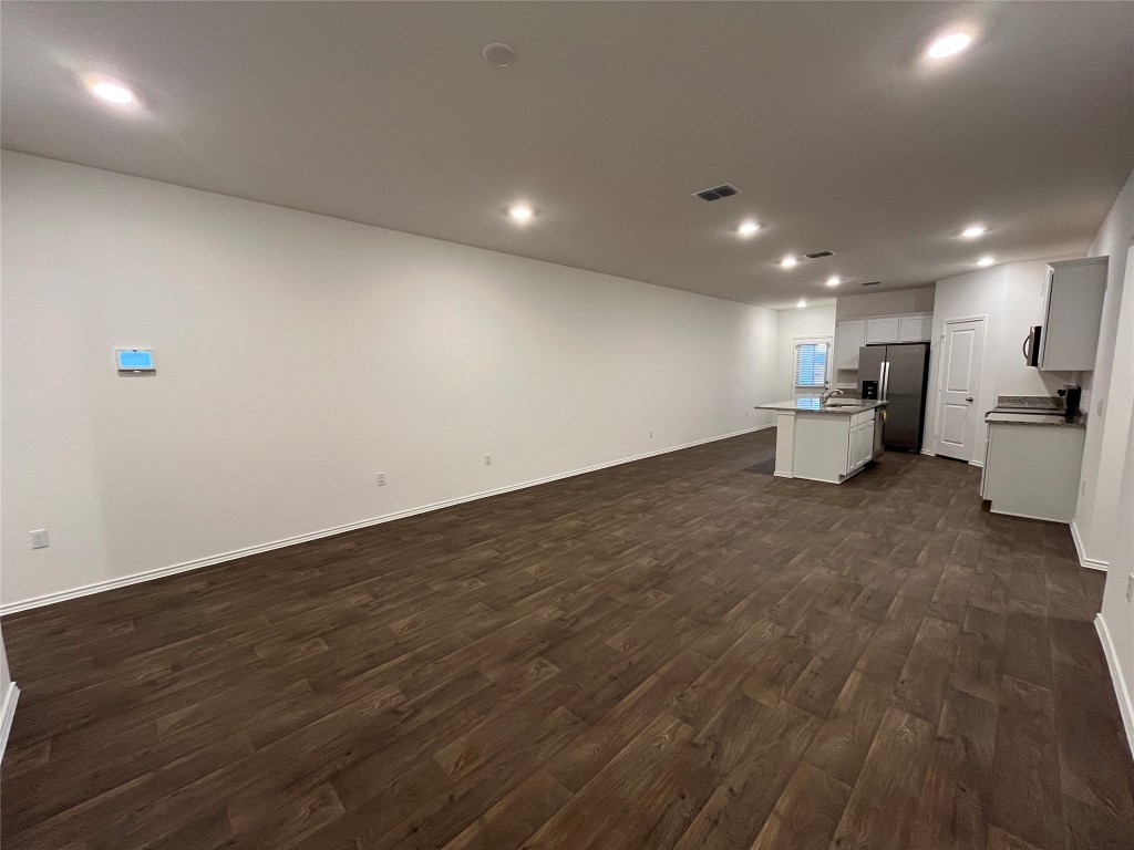 15016 B Welsh Cob Road, Unit B Manor, TX 78653 - Photo 2 of 14 an empty room with wooden floor and furniture