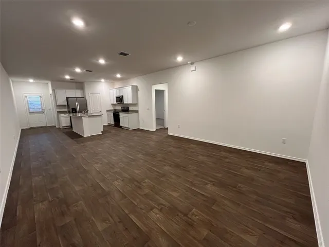 an empty room with wooden floor and furniture