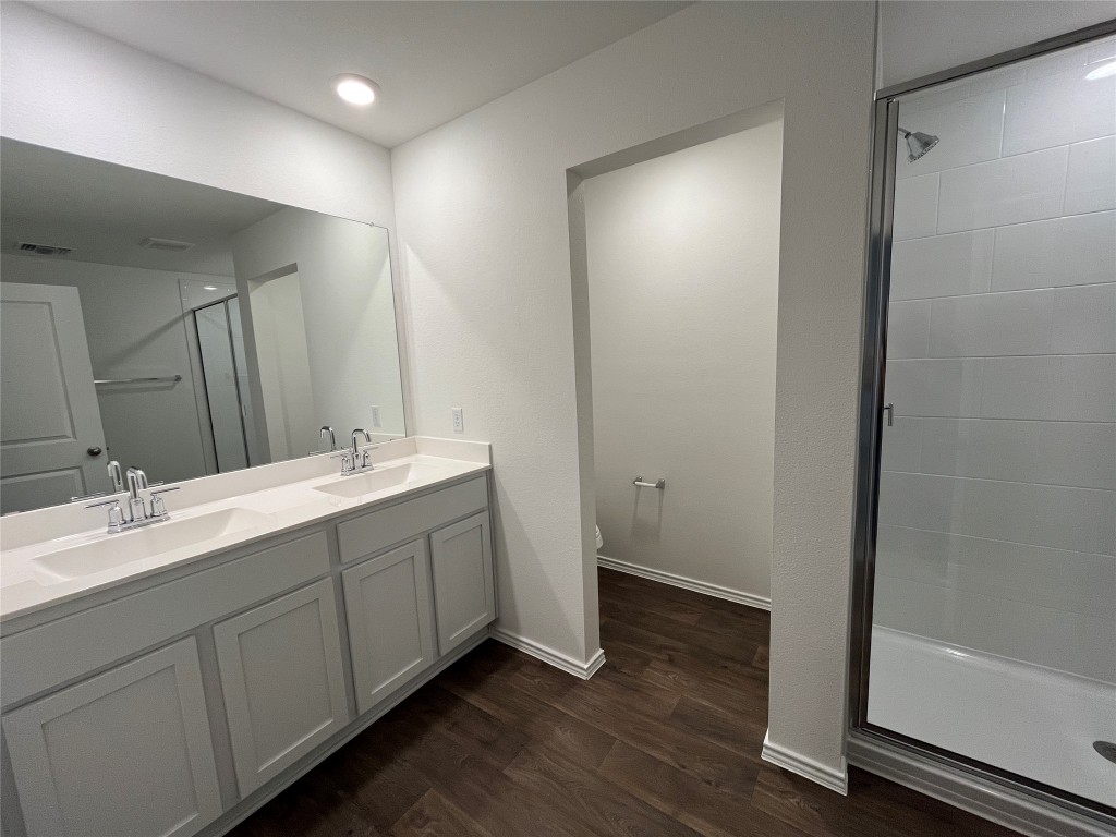 15016 B Welsh Cob Road, Unit B Manor, TX 78653 - Photo 8 of 14 a bathroom with double vanity and a mirror