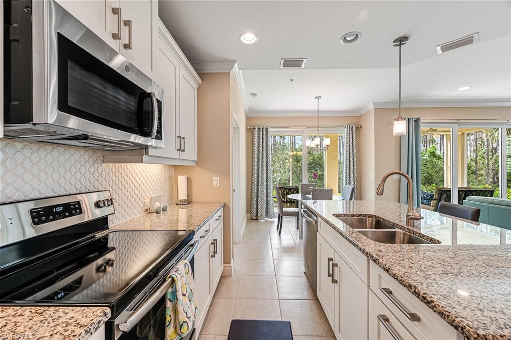 6969 Avalon Circle, Unit 1504 Naples, FL 34112 - Photo 16 of 42 a kitchen with stainless steel appliances granite countertop a sink and a stove