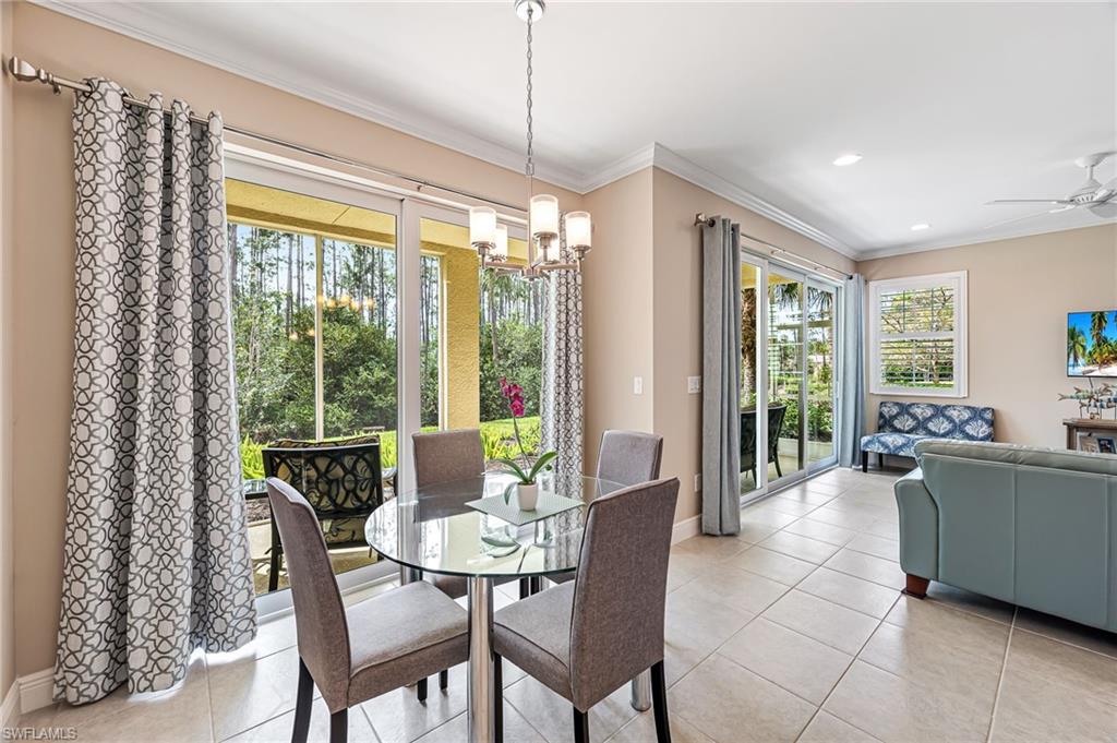 6969 Avalon Circle, Unit 1504 Naples, FL 34112 - Photo 17 of 42 a dining room with furniture a chandelier and glass door
