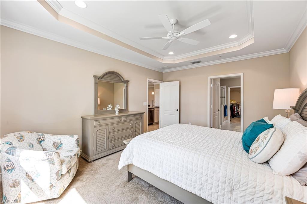 6969 Avalon Circle, Unit 1504 Naples, FL 34112 - Photo 20 of 42 a bedroom with a bed and a chandelier