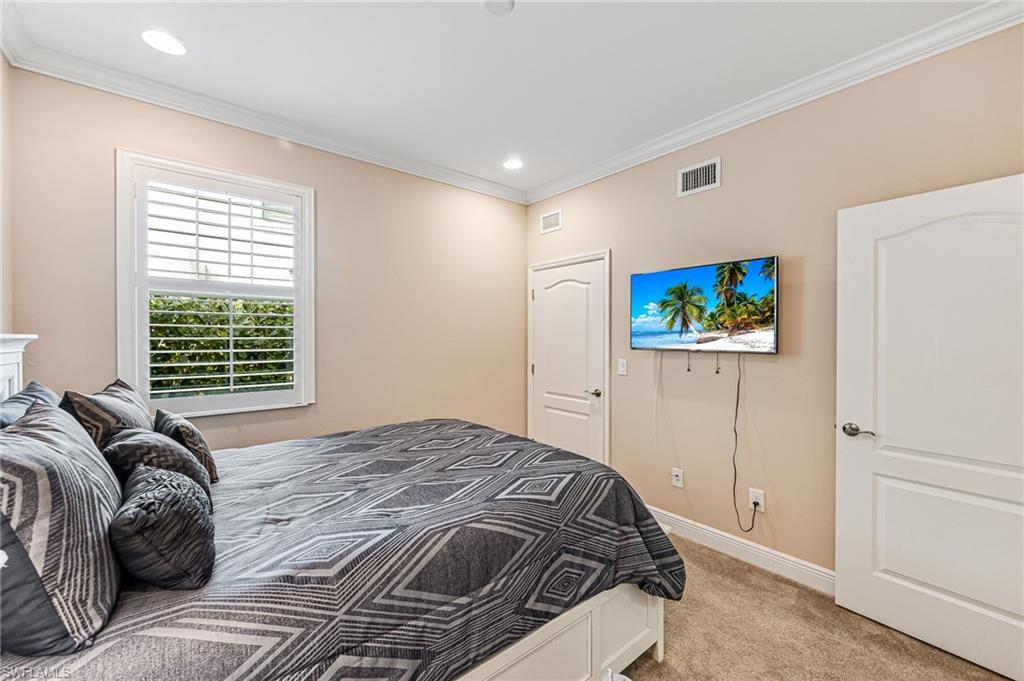6969 Avalon Circle, Unit 1504 Naples, FL 34112 - Photo 24 of 42 a bedroom with a bed and a window
