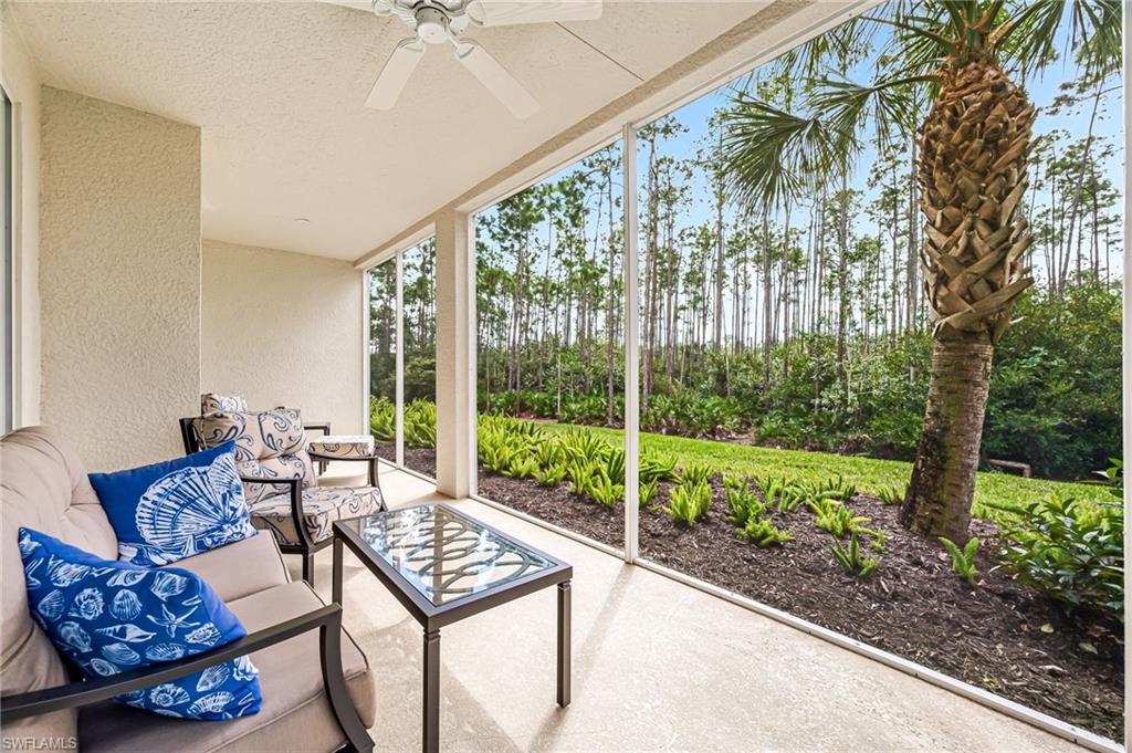6969 Avalon Circle, Unit 1504 Naples, FL 34112 - Photo 29 of 42 a living room with furniture and a floor to ceiling window