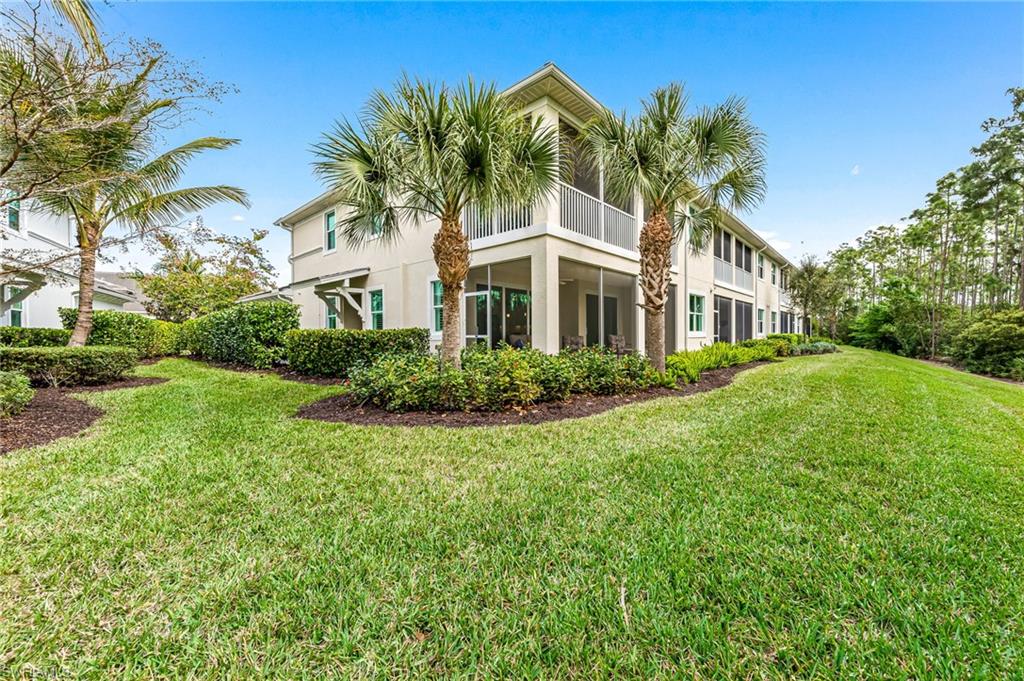 6969 Avalon Circle, Unit 1504 Naples, FL 34112 - Photo 30 of 42 a front view of a house with a garden