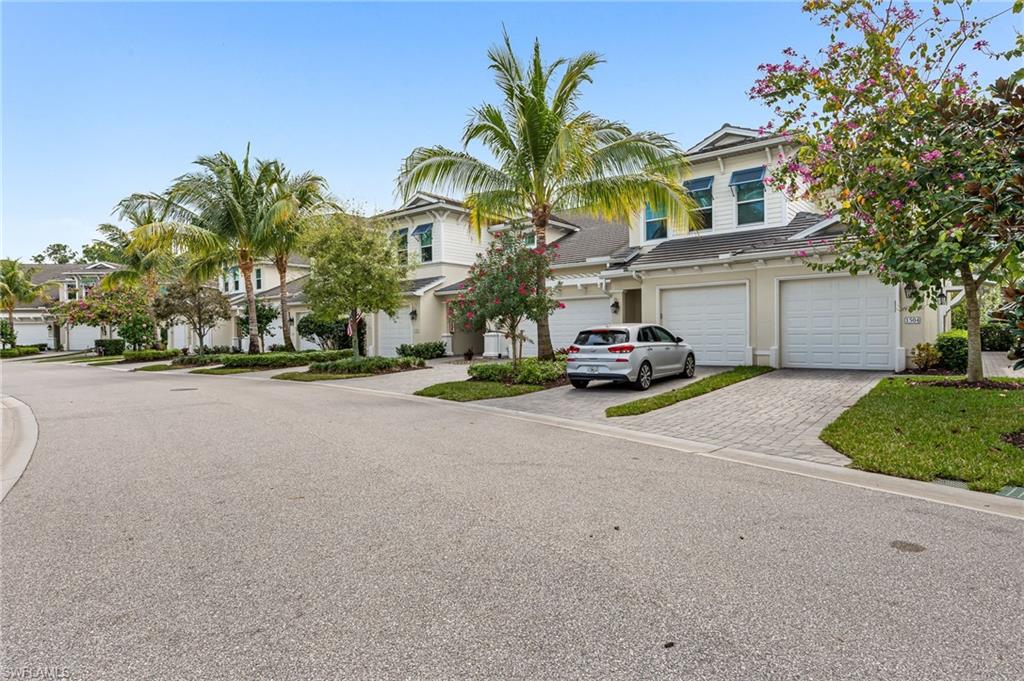 6969 Avalon Circle, Unit 1504 Naples, FL 34112 - Photo 31 of 42 a car parked in front of a house with a yard