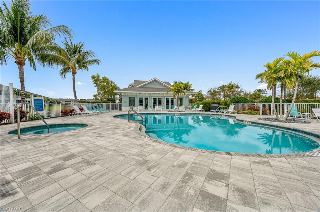 6969 Avalon Circle, Unit 1504 Naples, FL 34112 - Photo 37 of 42 a view of a swimming pool with a yard and palm trees