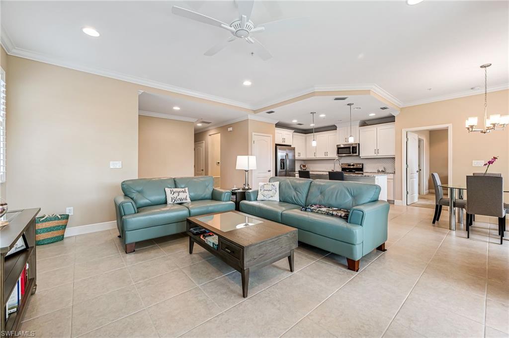 6969 Avalon Circle, Unit 1504 Naples, FL 34112 - Photo 9 of 42 a living room with furniture and a chandelier