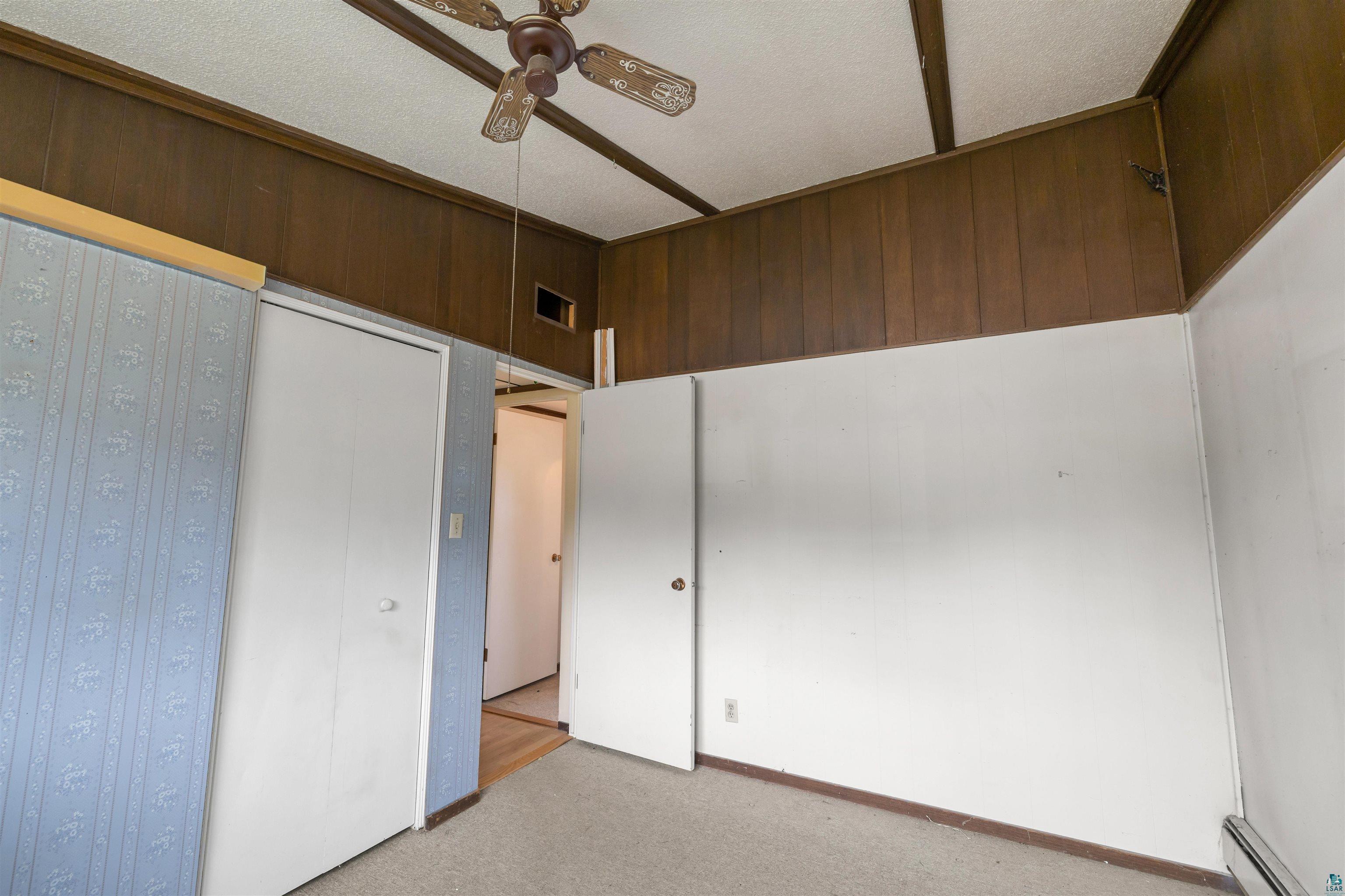 11574 Town Line Road Hibbing, MN 55746 - Photo 14 of 41 Carpeted interior space featuring white walls and wood-paneled accents