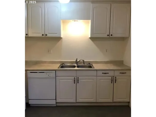 a kitchen with stainless steel appliances granite countertop white cabinets and a stove