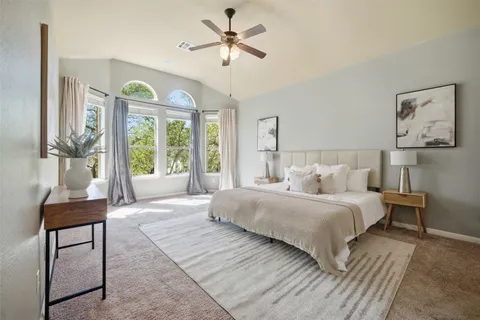 a bedroom with a large bed and a chandelier