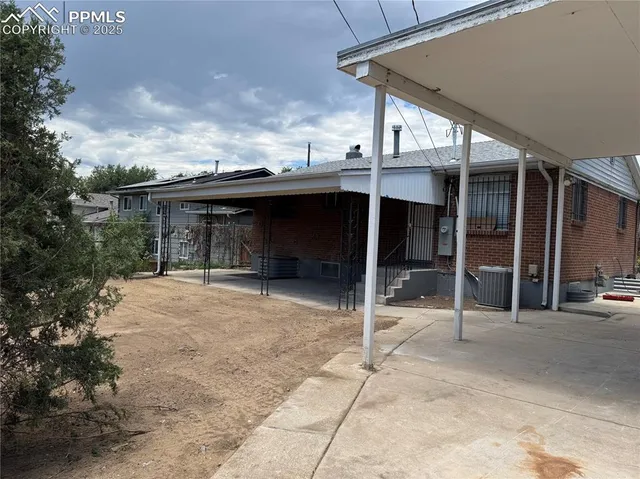 a backyard of a house with basket ball court and ceiling fan