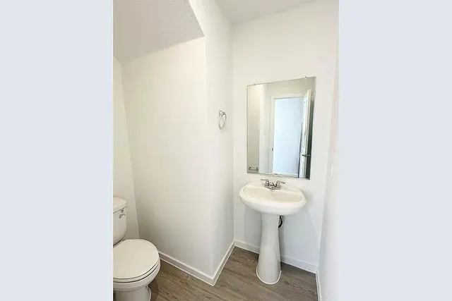 a bathroom with a sink toilet and a mirror