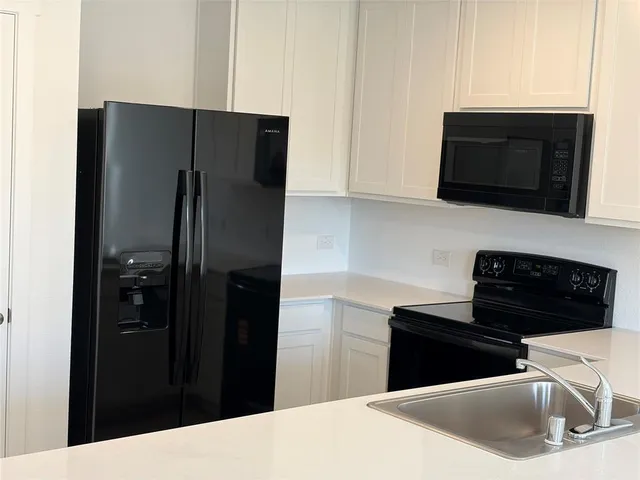 a kitchen with a refrigerator stove and microwave
