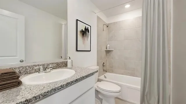 a bathroom with a granite countertop sink toilet and shower
