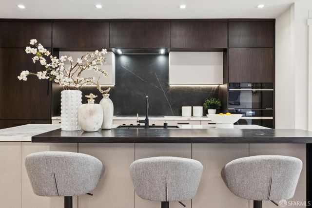 a kitchen with stainless steel appliances kitchen island granite countertop a refrigerator a sink a stove and a cabinets