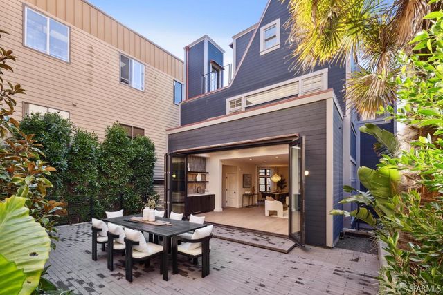 a view of a dinning table and chairs in patio of the house