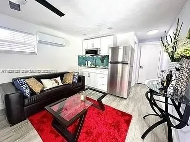 a living room with furniture and a refrigerator